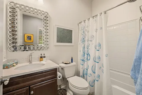 a bathroom with a sink a toilet and shower curtain