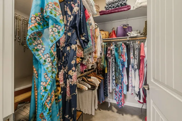 a view of walk in closet with clothes