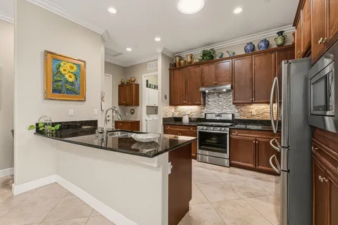 a kitchen with stainless steel appliances granite countertop a sink stove and refrigerator
