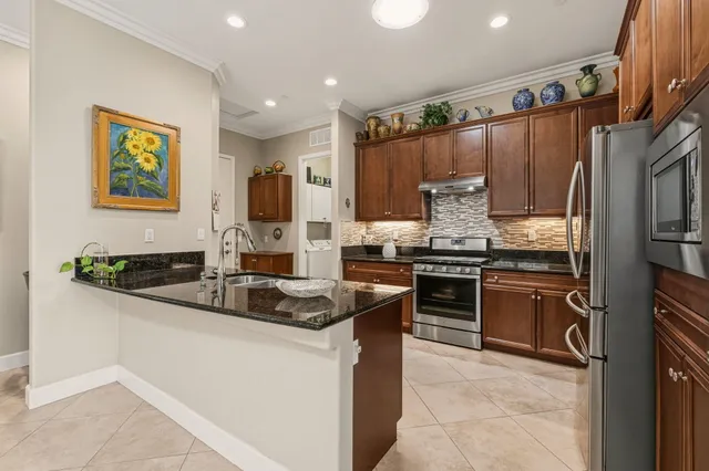 a kitchen with stainless steel appliances granite countertop a sink stove and refrigerator