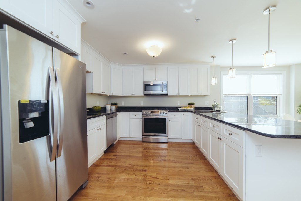 a kitchen with stainless steel appliances granite countertop a refrigerator a sink and a stove