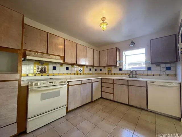 a kitchen with cabinets appliances and a sink