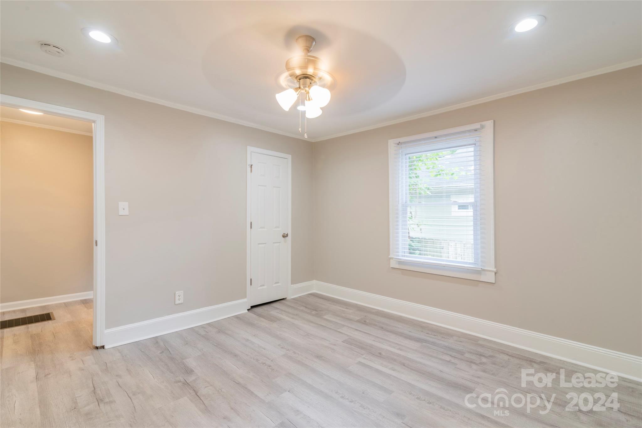 2336 Barry Street, Unit B Charlotte, NC 28205 - Photo 11 of 18 an empty room with wooden floor chandelier and windows