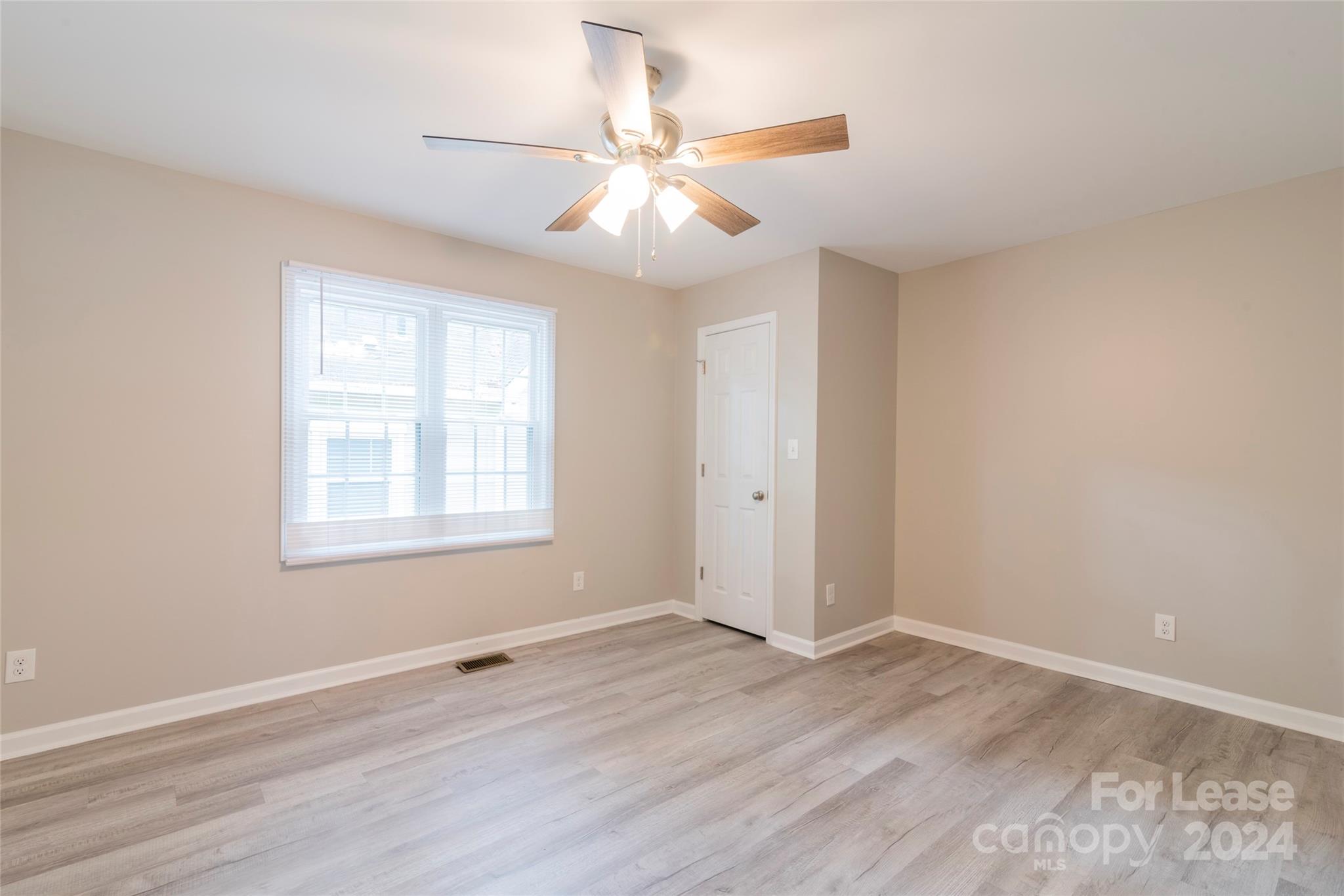 2336 Barry Street, Unit B Charlotte, NC 28205 - Photo 14 of 18 an empty room with wooden floor fan and windows
