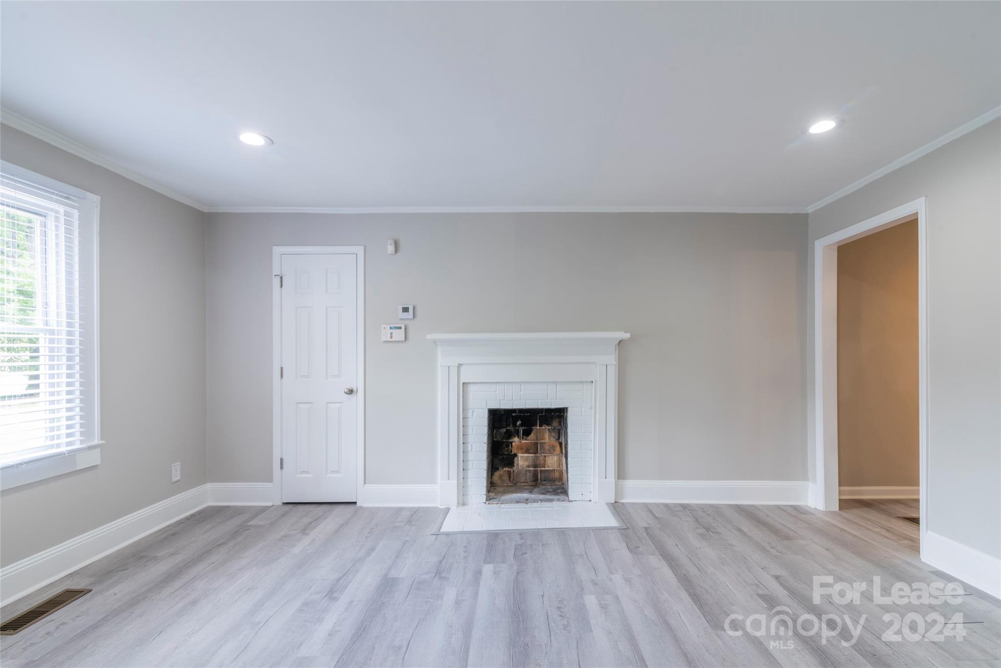 2336 Barry Street, Unit B Charlotte, NC 28205 - Photo 2 of 18 an empty room with wooden floor fireplace and windows