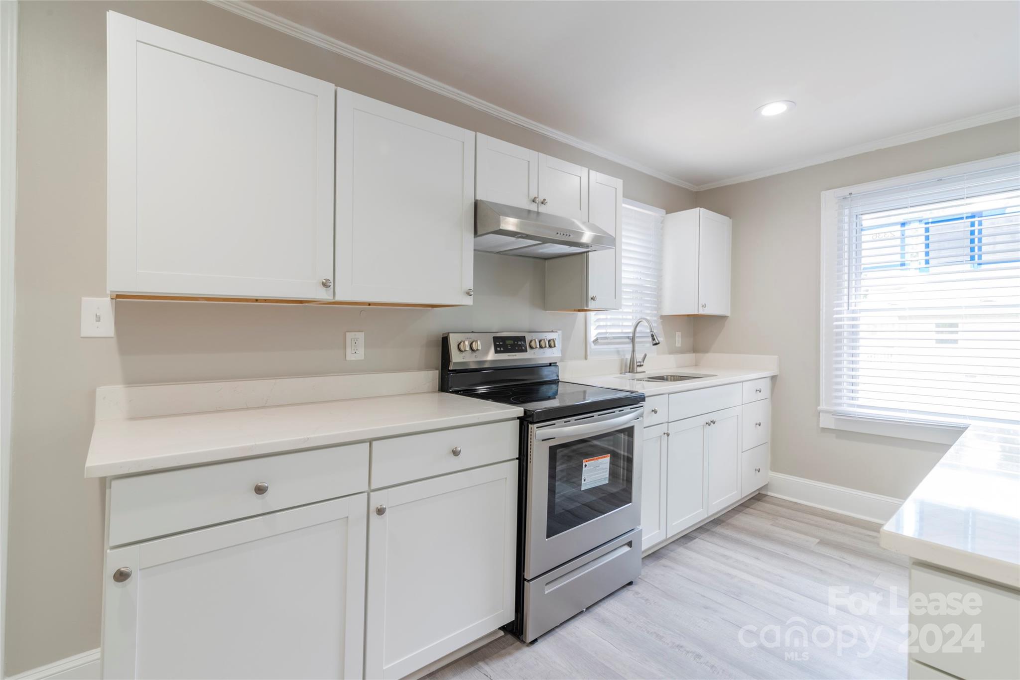 2336 Barry Street, Unit B Charlotte, NC 28205 - Photo 6 of 18 a kitchen with granite countertop white cabinets and white appliances