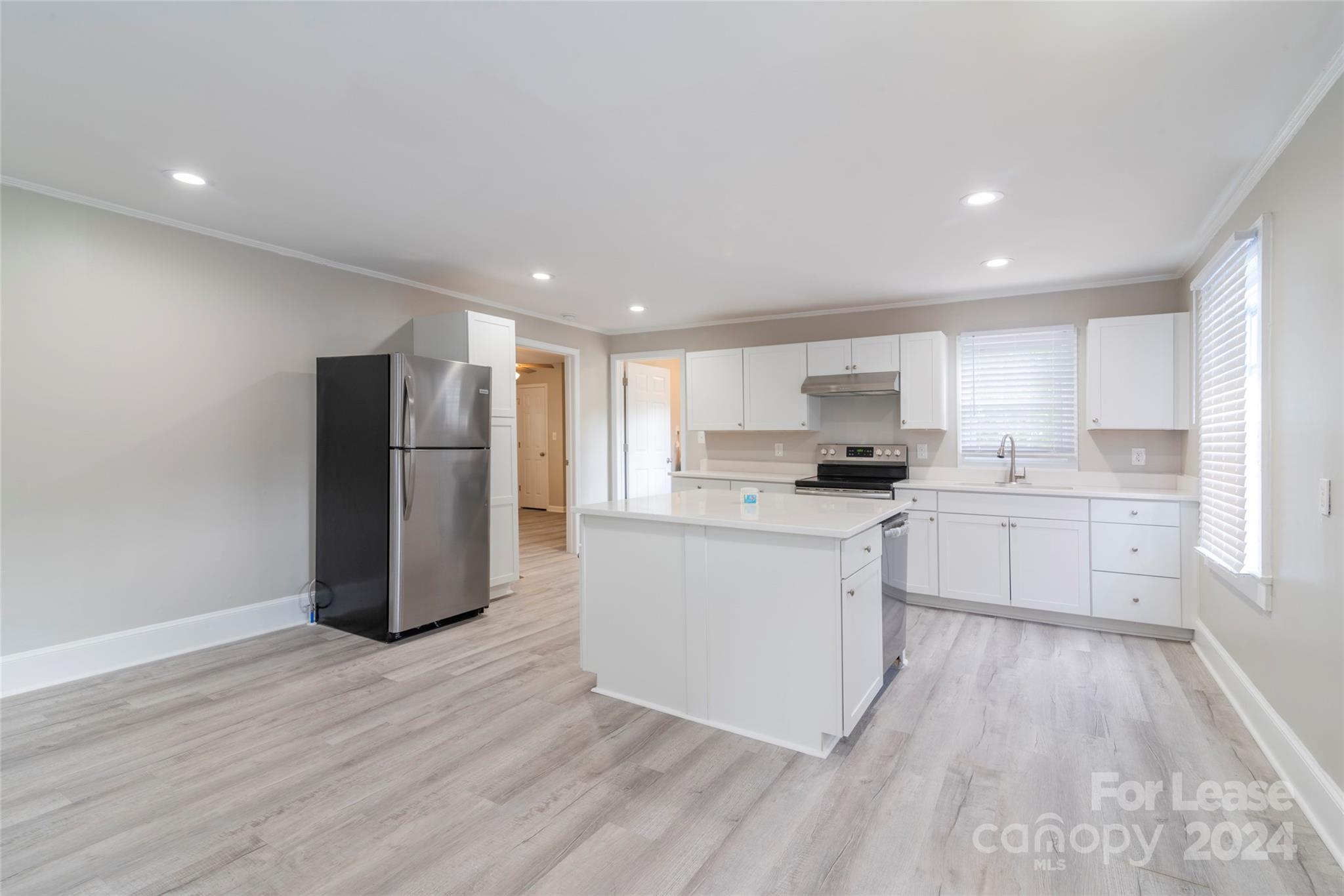 2336 Barry Street, Unit B Charlotte, NC 28205 - Photo 7 of 18 a kitchen with stainless steel appliances granite countertop a refrigerator sink and white cabinets