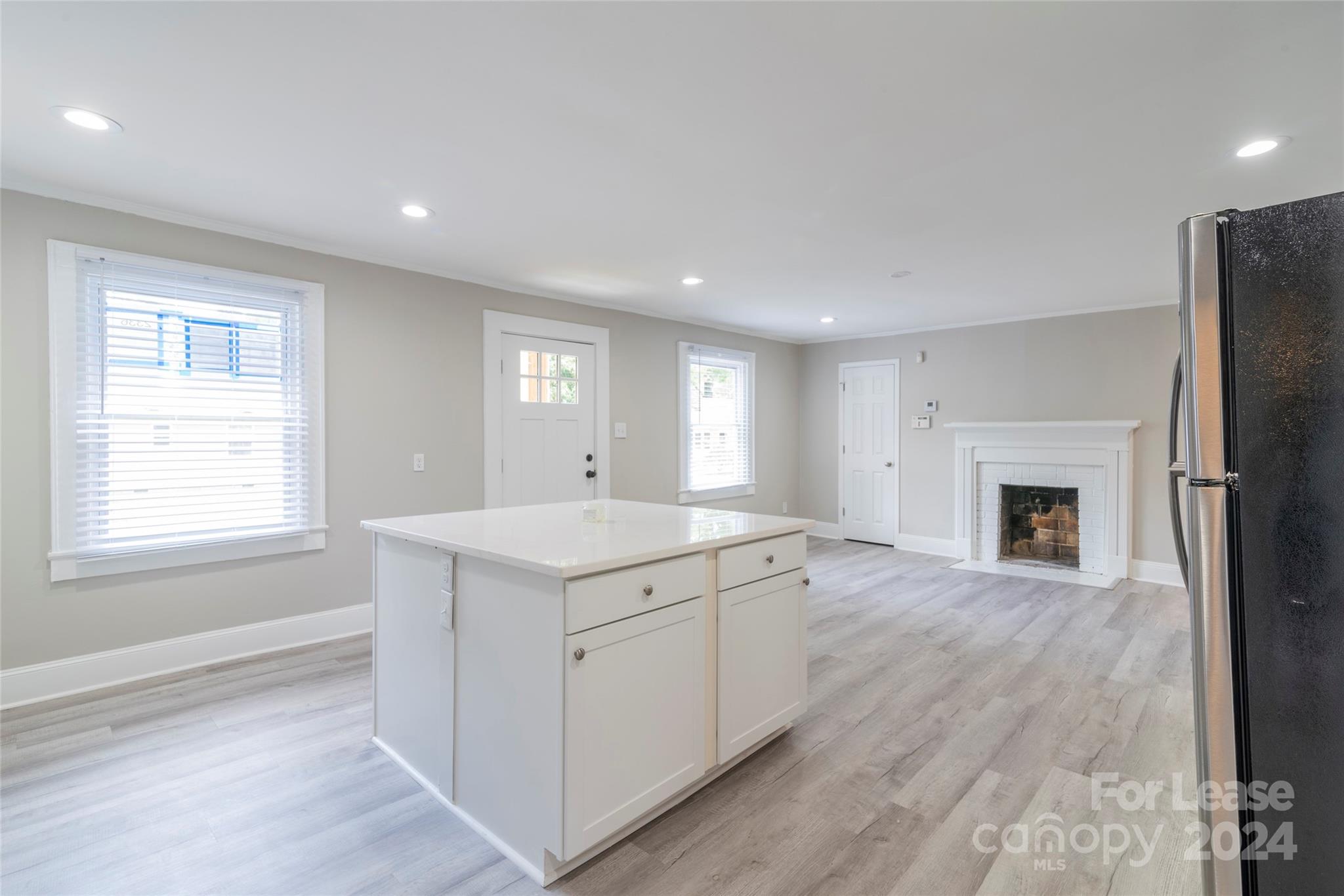 2336 Barry Street, Unit B Charlotte, NC 28205 - Photo 8 of 18 an empty room with a fireplace and wooden floor