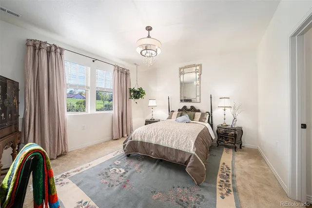 a bedroom with a bed and a dresser next to a window