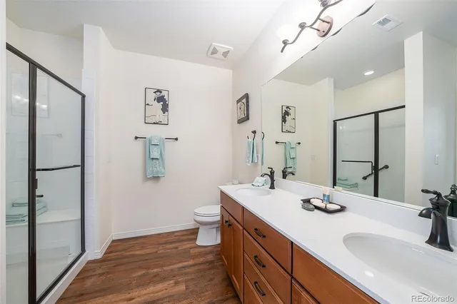 a bathroom with a double vanity sink mirror and toilet