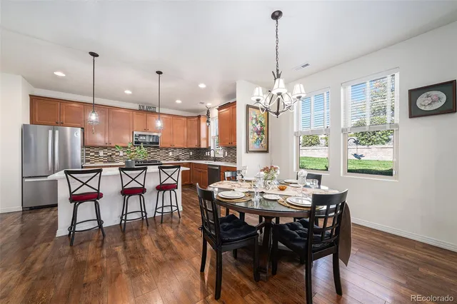 a view of a dining room and livingroom with furniture wooden floor a chandelier