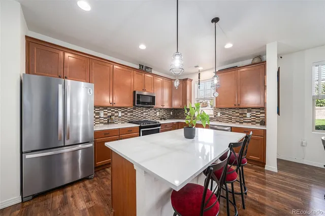 a kitchen with stainless steel appliances a refrigerator a stove a sink and a refrigerator