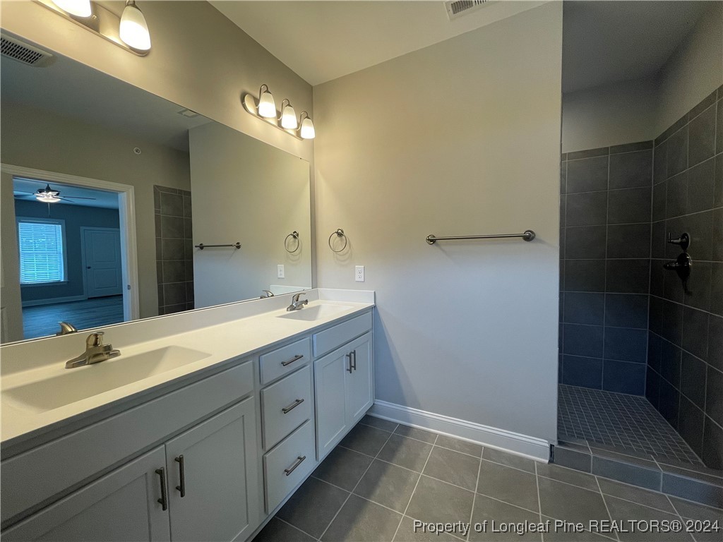 240 Gallery Drive, Unit 304 Spring Lake, NC 28390 - Photo 5 of 16 a spacious bathroom with a double vanity sink a toilet and a mirror