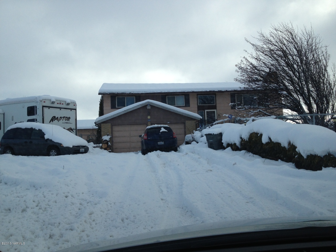 a front view of a house with cars parked