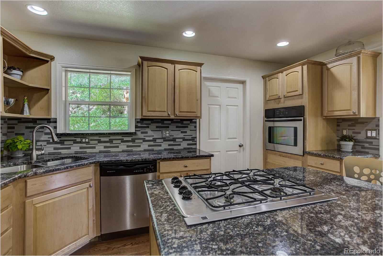 4961 Little Cub Creek Road Evergreen, CO 80439 - Photo 11 of 38 a kitchen with stainless steel appliances granite countertop a stove a sink dishwasher and a microwave