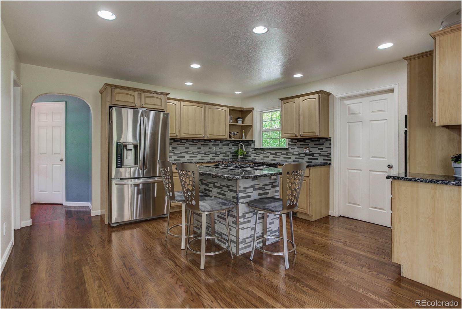4961 Little Cub Creek Road Evergreen, CO 80439 - Photo 12 of 38 a kitchen with stainless steel appliances a refrigerator and wooden floor