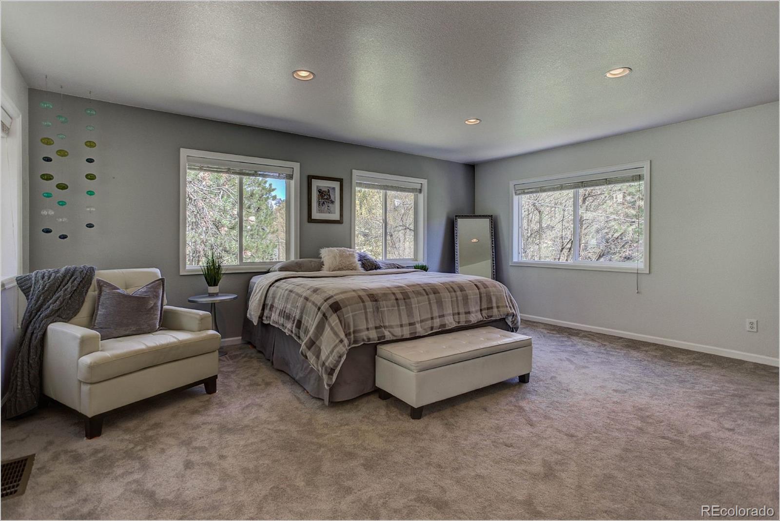4961 Little Cub Creek Road Evergreen, CO 80439 - Photo 18 of 38 a bedroom with a bed couch and windows