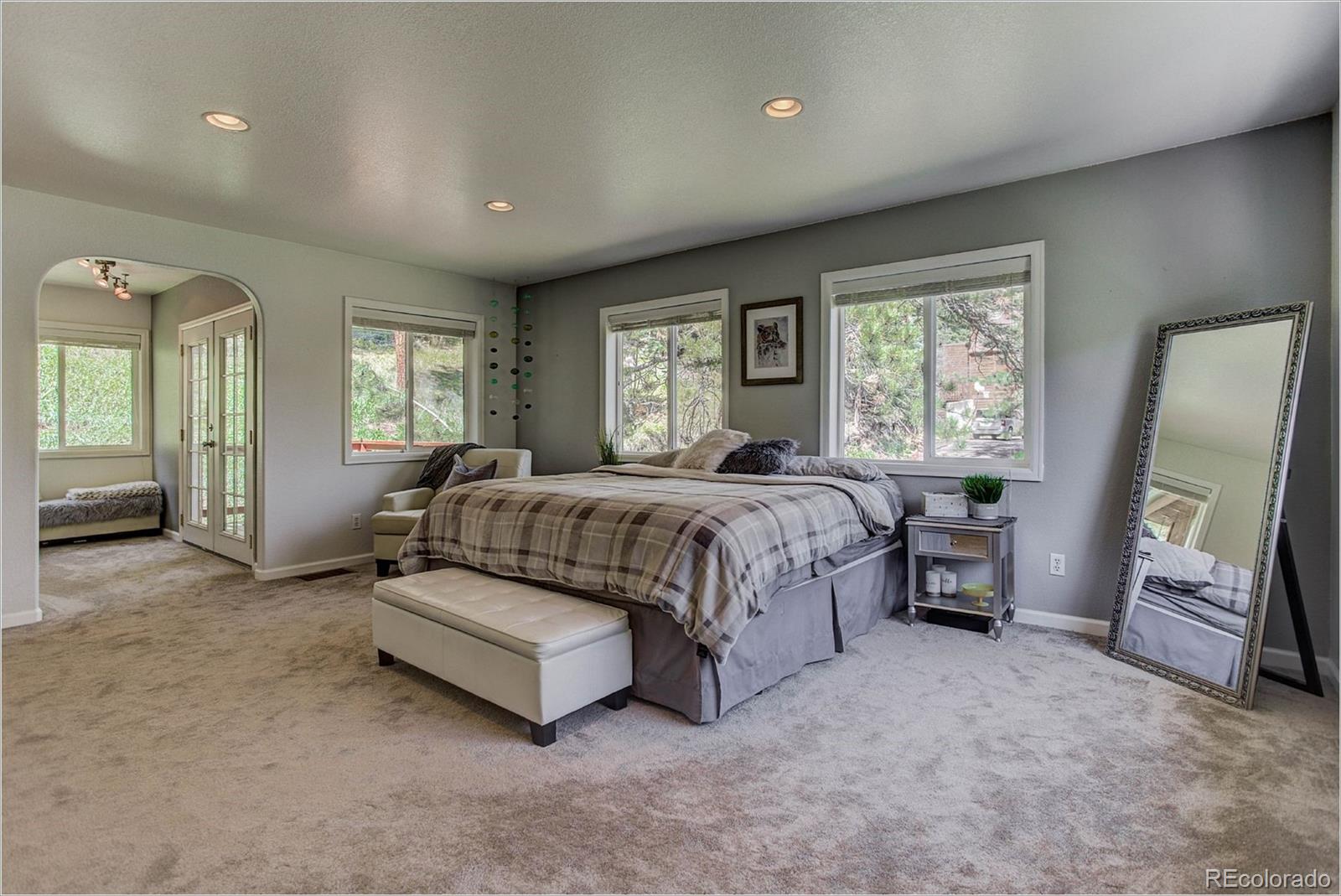 4961 Little Cub Creek Road Evergreen, CO 80439 - Photo 19 of 38 a spacious bedroom with a bed a couch and dresser