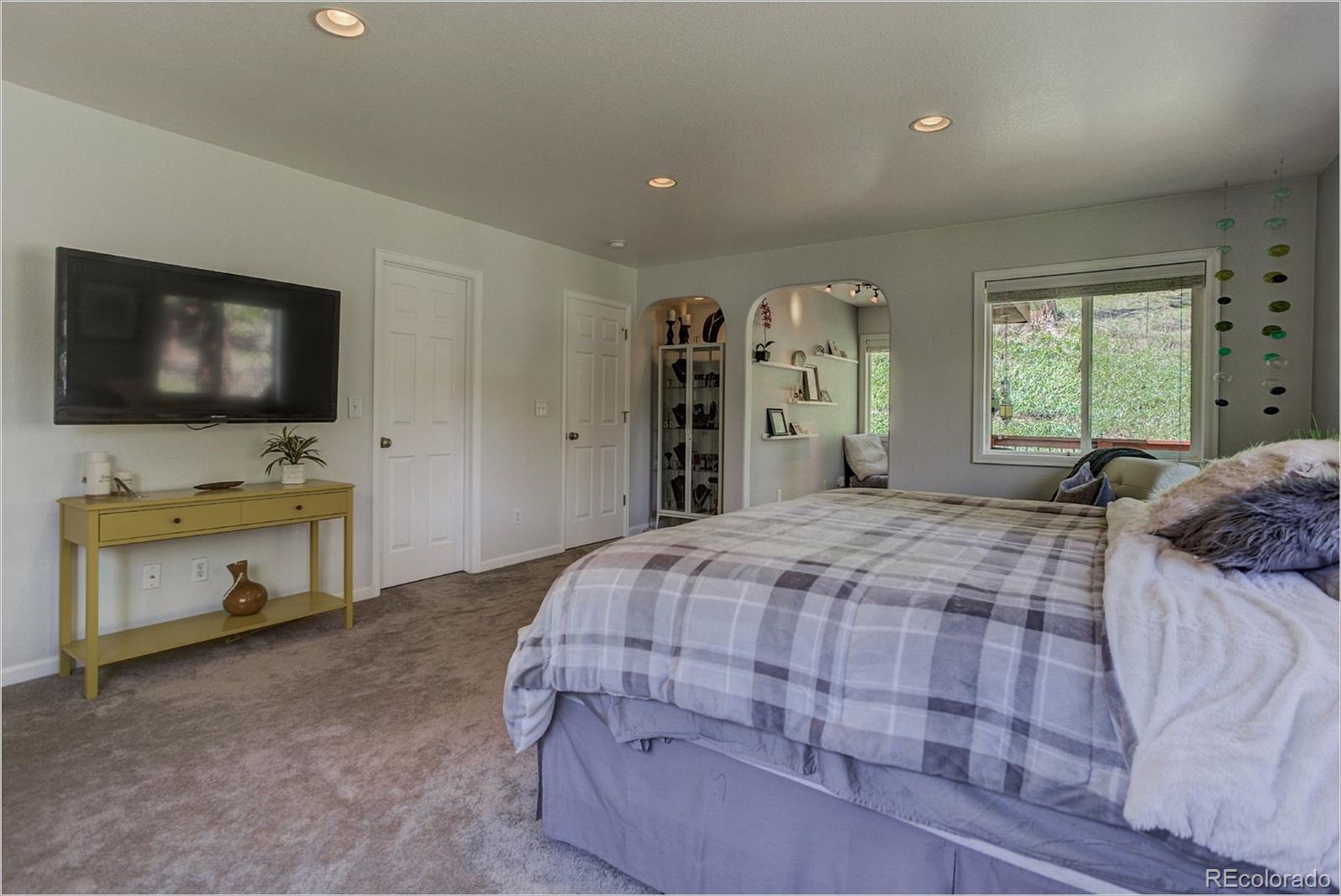 4961 Little Cub Creek Road Evergreen, CO 80439 - Photo 20 of 38 a bedroom with a bed and a flat screen tv