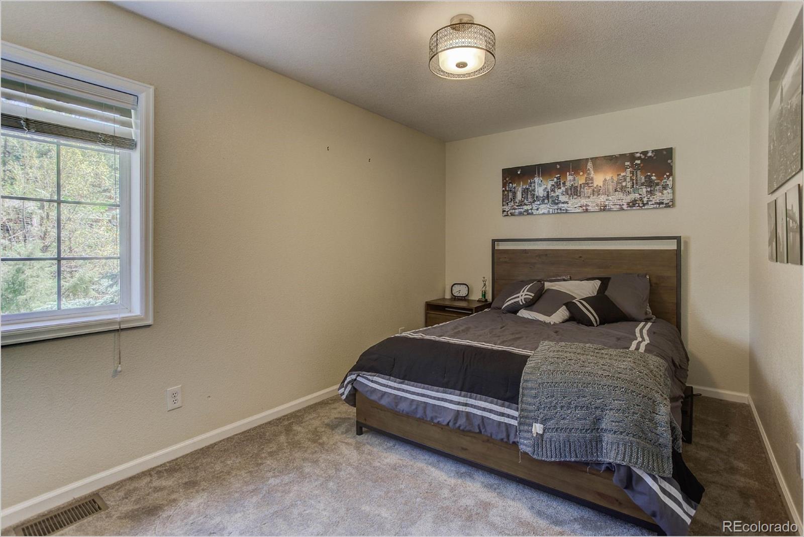 4961 Little Cub Creek Road Evergreen, CO 80439 - Photo 27 of 38 a bedroom with bed and a window