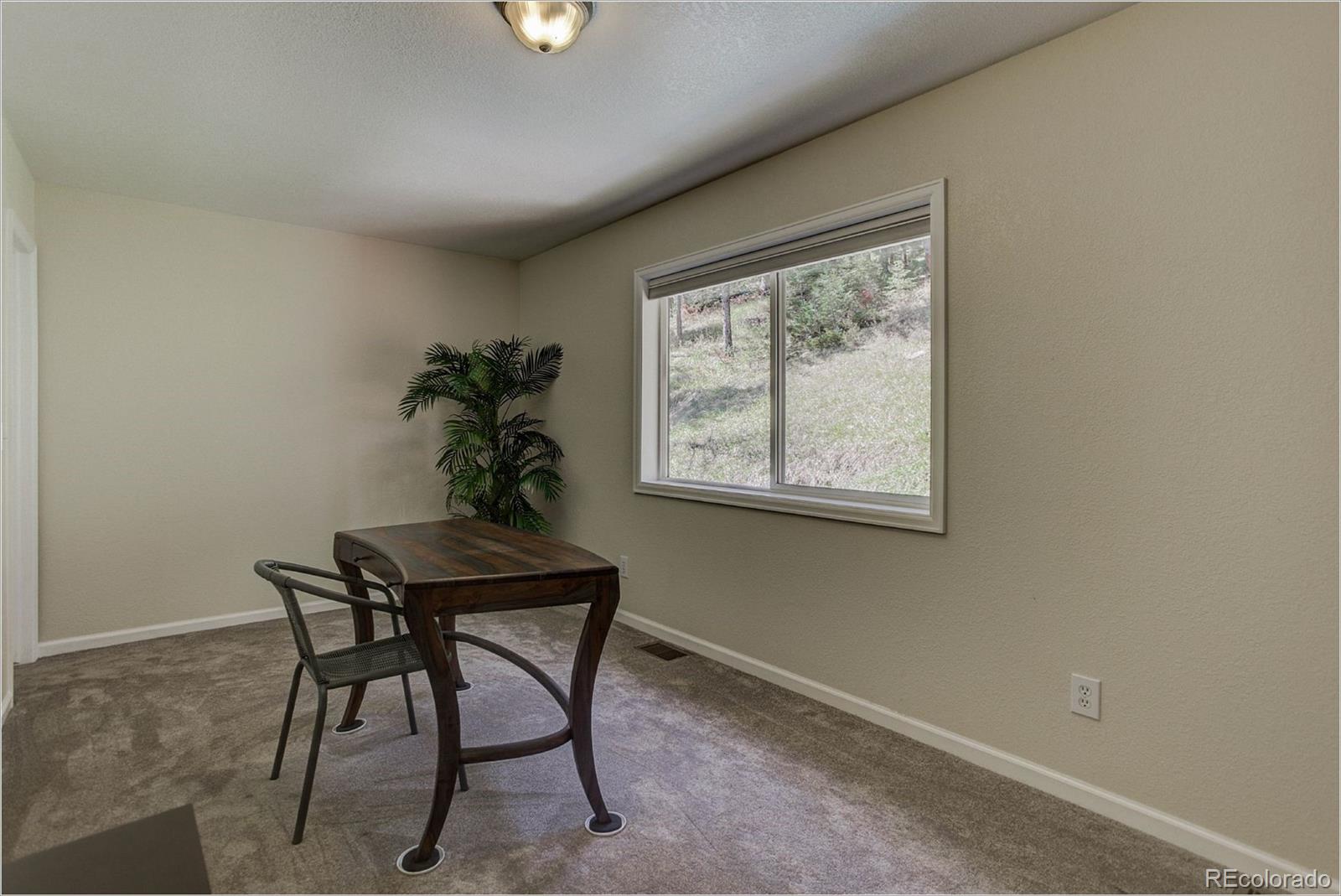 4961 Little Cub Creek Road Evergreen, CO 80439 - Photo 30 of 38 a view of a room that has a window and a potted plant on a table