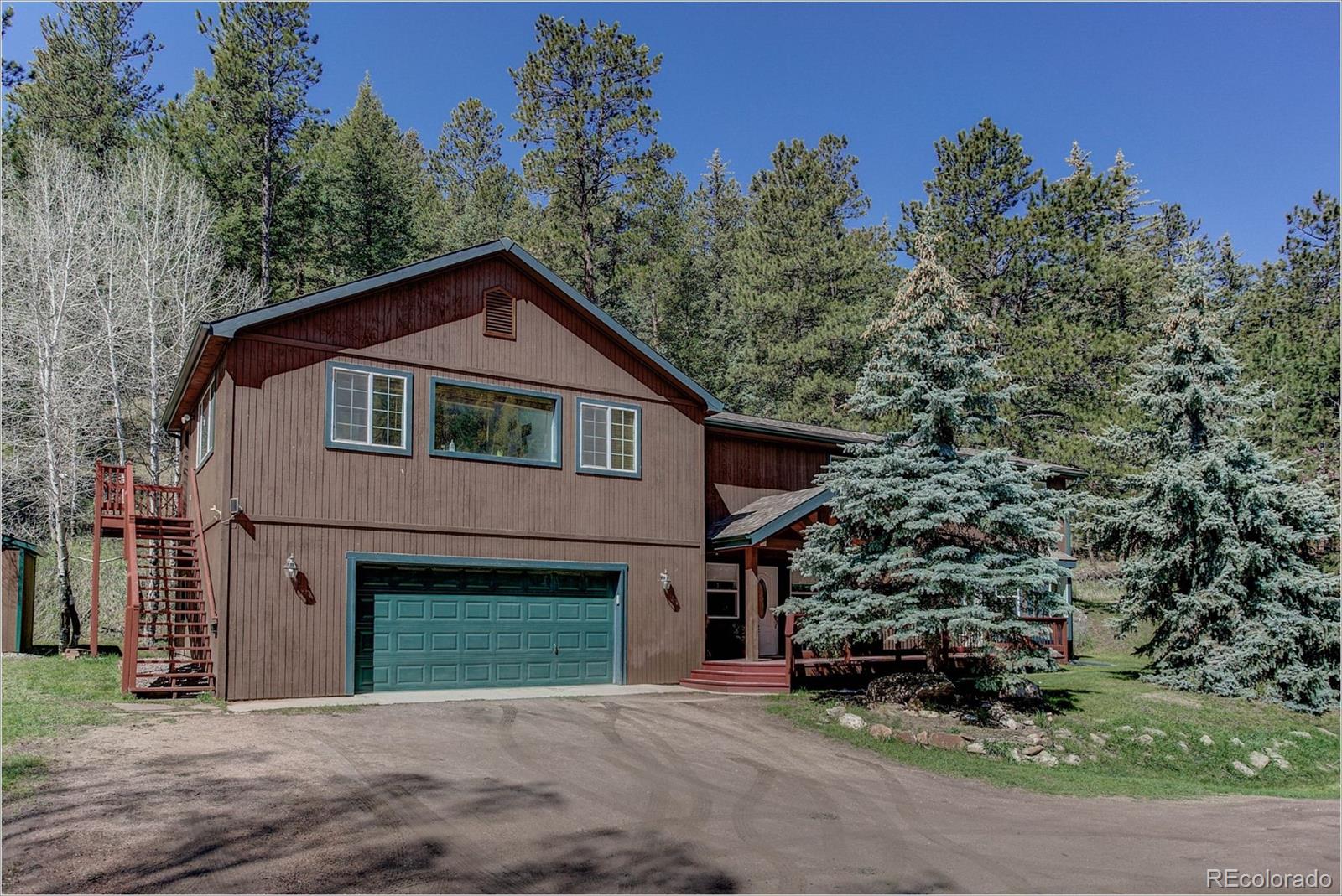 4961 Little Cub Creek Road Evergreen, CO 80439 - Photo 3 of 38 a front view of a house with a garden