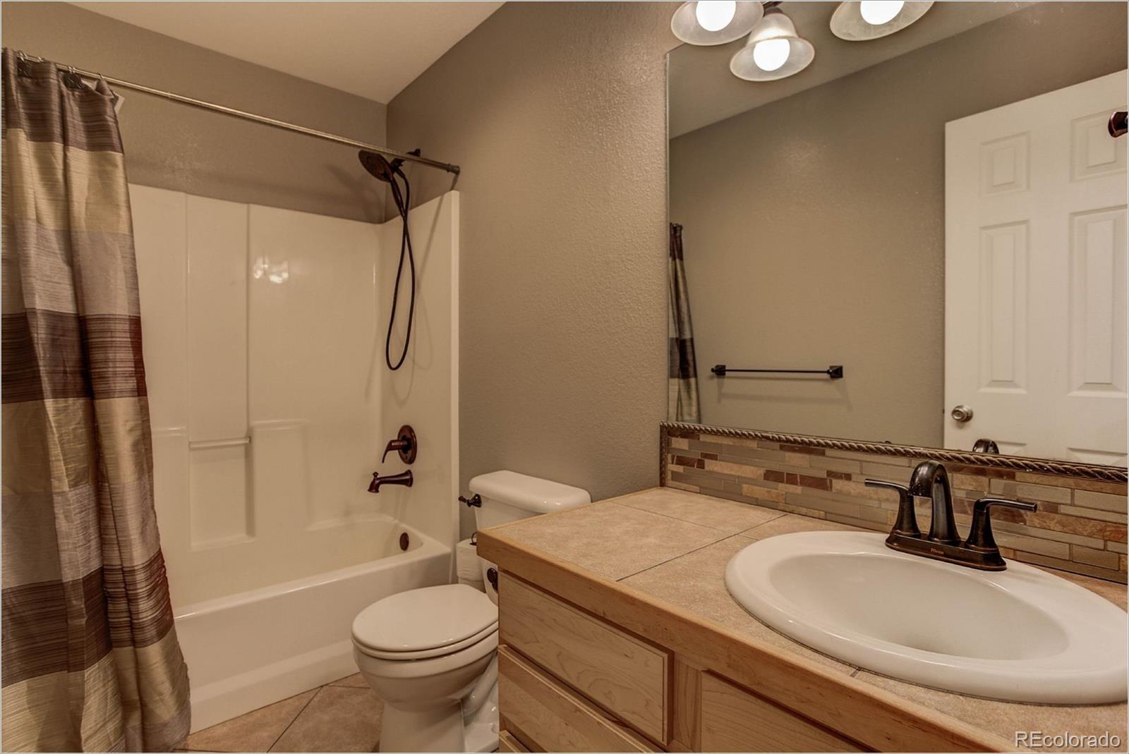 4961 Little Cub Creek Road Evergreen, CO 80439 - Photo 31 of 38 a bathroom with a granite countertop sink toilet and shower