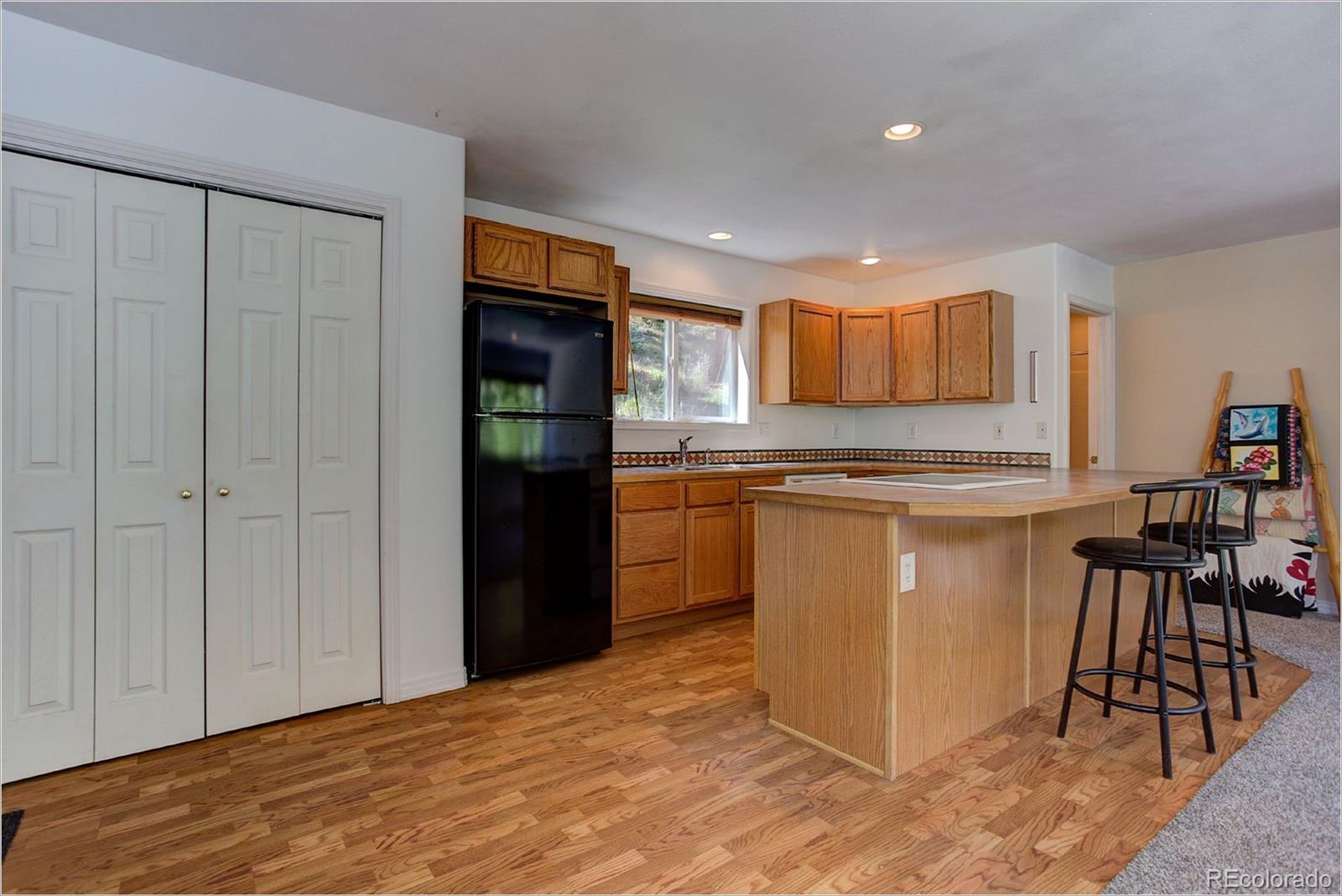 4961 Little Cub Creek Road Evergreen, CO 80439 - Photo 32 of 38 a kitchen with stainless steel appliances granite countertop a refrigerator and a stove top oven