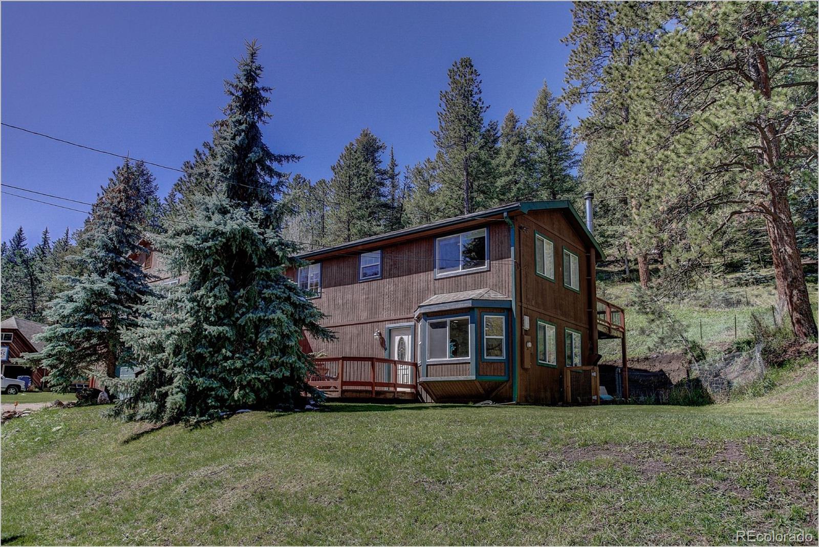 4961 Little Cub Creek Road Evergreen, CO 80439 - Photo 4 of 38 a view of house with yard and trees in the background