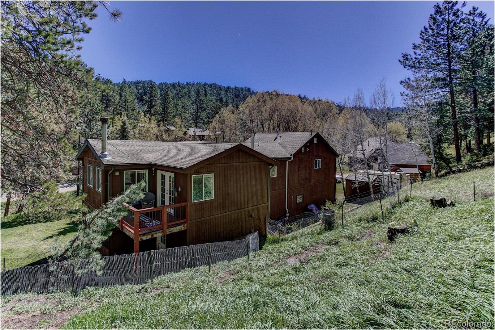 4961 Little Cub Creek Road Evergreen, CO 80439 - Photo 5 of 38 a front view of a house with a yard
