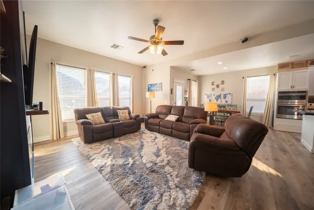 a living room with furniture wooden floor and a large window