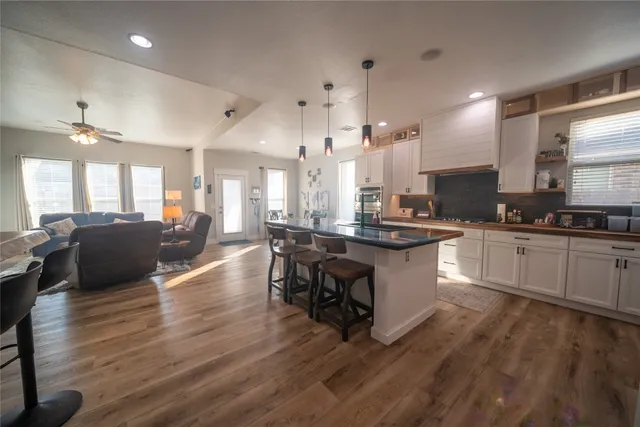 a large white kitchen with lots of counter space a sink and appliances