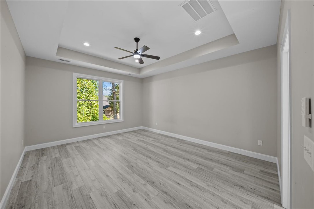 105 Bree Drive Anderson, SC 29621 - Photo 18 of 48 A spacious room offers comfortable living with a decorative tray ceiling and hardwood flooring.