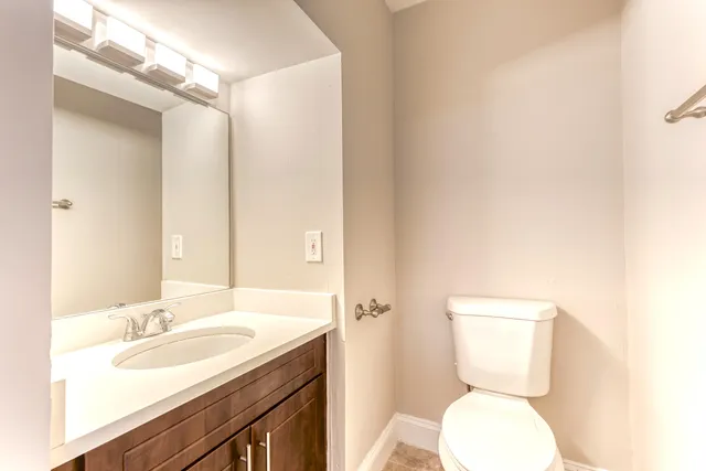 a bathroom with a toilet a sink and mirror