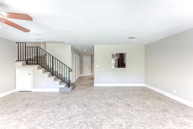 a view of a hallway with entryway and stairs
