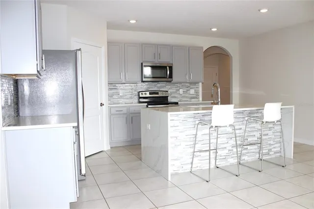 a kitchen with granite countertop a stove and a microwave