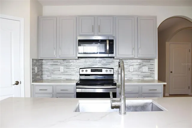 a kitchen with white cabinets and stainless steel appliances