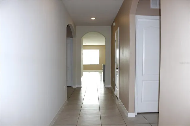a hallway with wooden floor windows and a bathroom