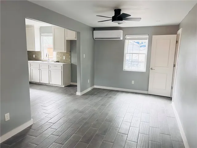 a view of a kitchen with wooden floor and a window