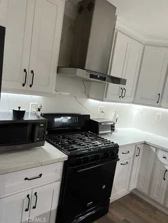 a hallway with table and white stainless steel appliances