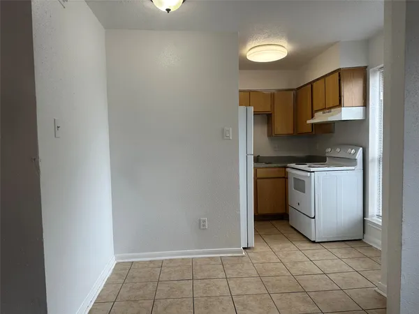 a kitchen with white cabinets and white appliances