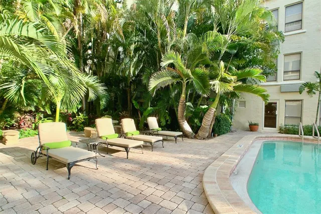 a view of a swimming pool with lounge chairs in patio