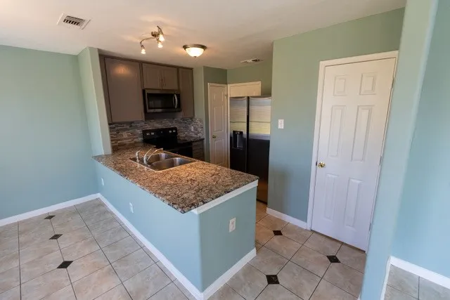 a kitchen with sink cabinets and refrigerator