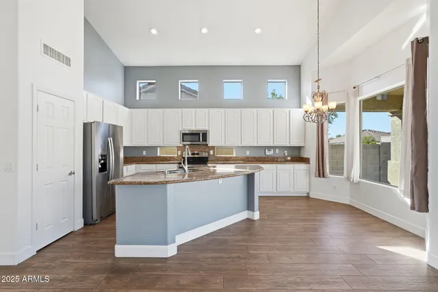 a kitchen with stainless steel appliances a refrigerator and a stove top oven