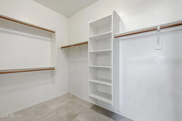 a view of walk in closet with empty racks