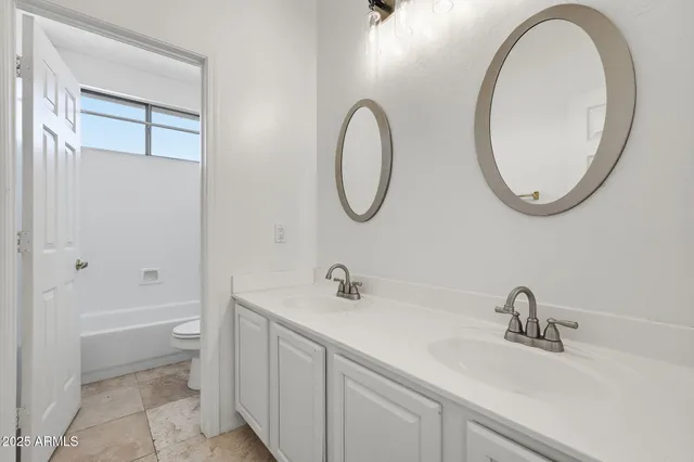 a bathroom with a sink a toilet and a mirror