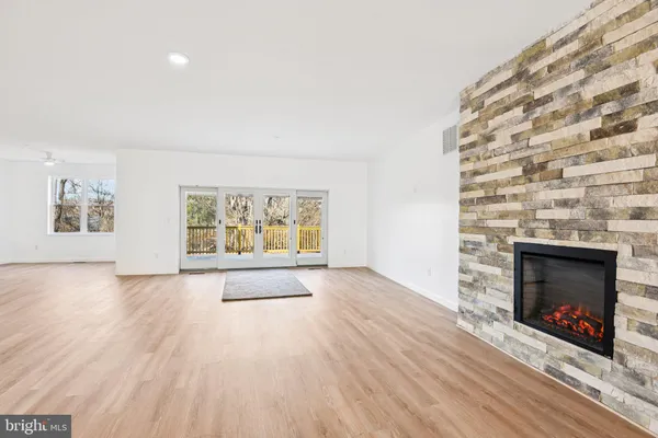 an empty room with windows and fireplace