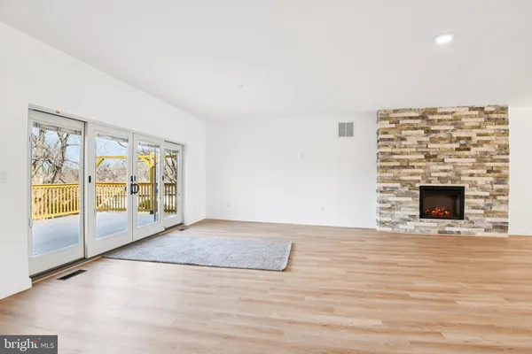 a view of an empty room with glass door and a window