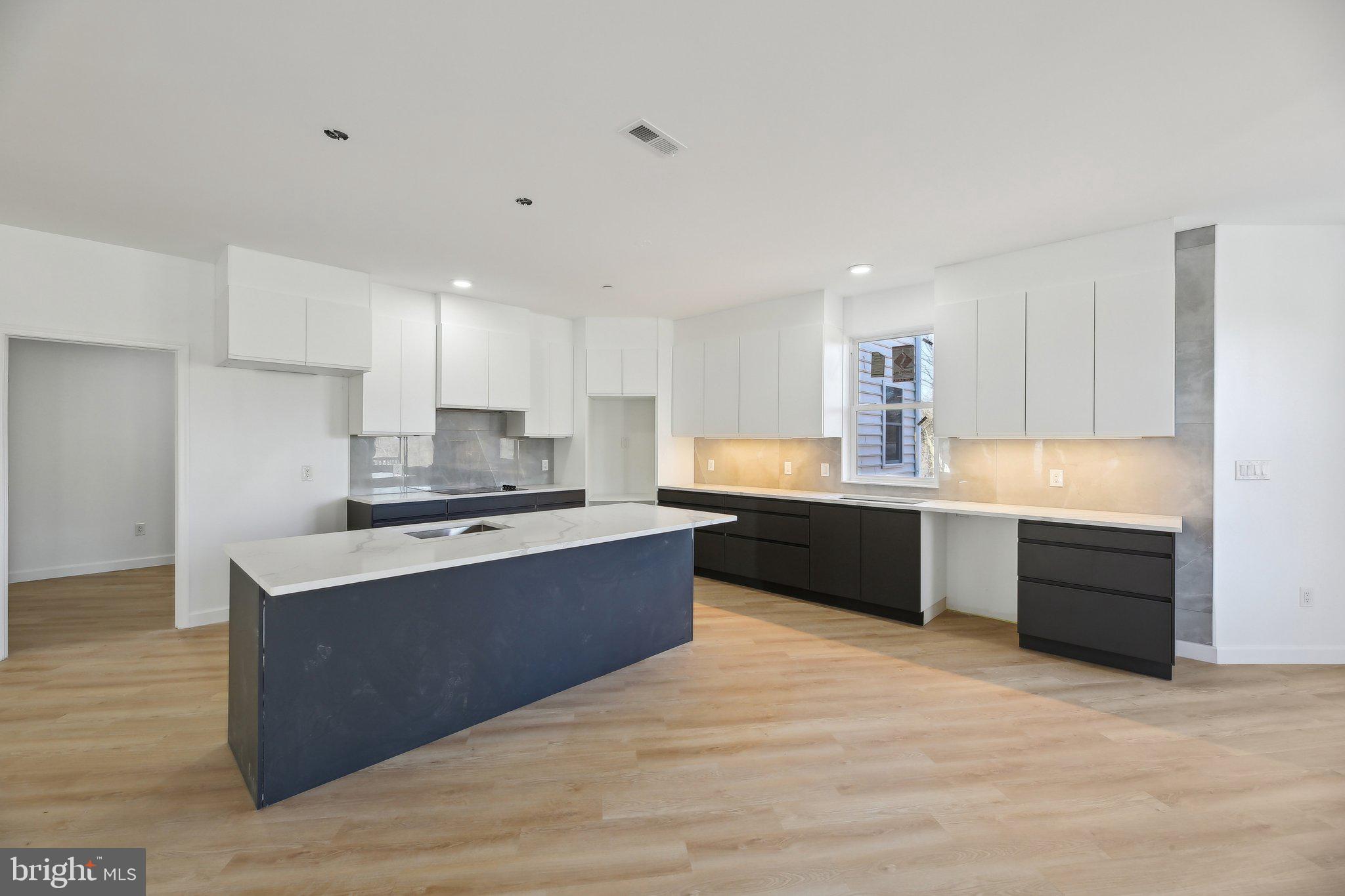 8325 Grove Angle Road Ellicott City, MD 21043 - Photo 12 of 57 a large kitchen with a large counter top stainless steel appliances and cabinets