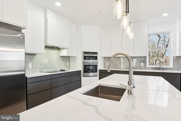 a large kitchen with kitchen island a sink stainless steel appliances and a window